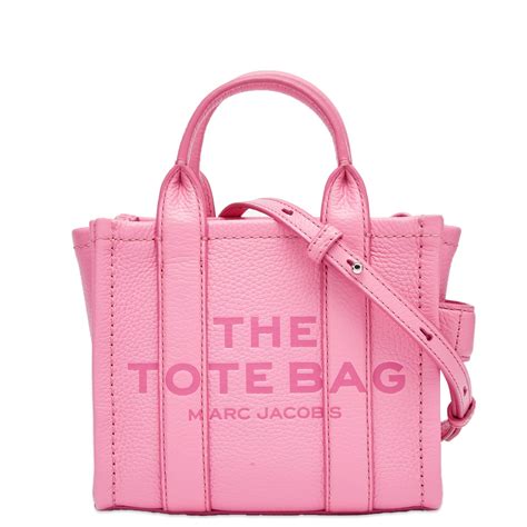 Candy pink marc jacobs tote bag - This is an authentic MARC JACOBS Grained Calfskin Small The Tote Bag in Candy Pink. This chic tote bag is beautifully crafted of grained calfskin leather in pink. The bag features top handles, an optional adjustable shoulder strap with silver hardware, and an embossed print on the front. The top zipper opens to a spacious orange leather ...